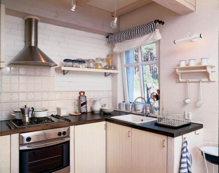 Prosta jasna kuchnia z subtelnymi elementami dekoracyjnymi.