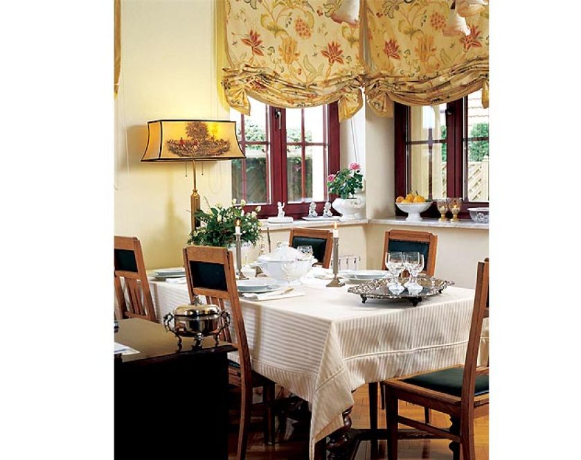 W oknach wiszą rolety w kieciste motywy.