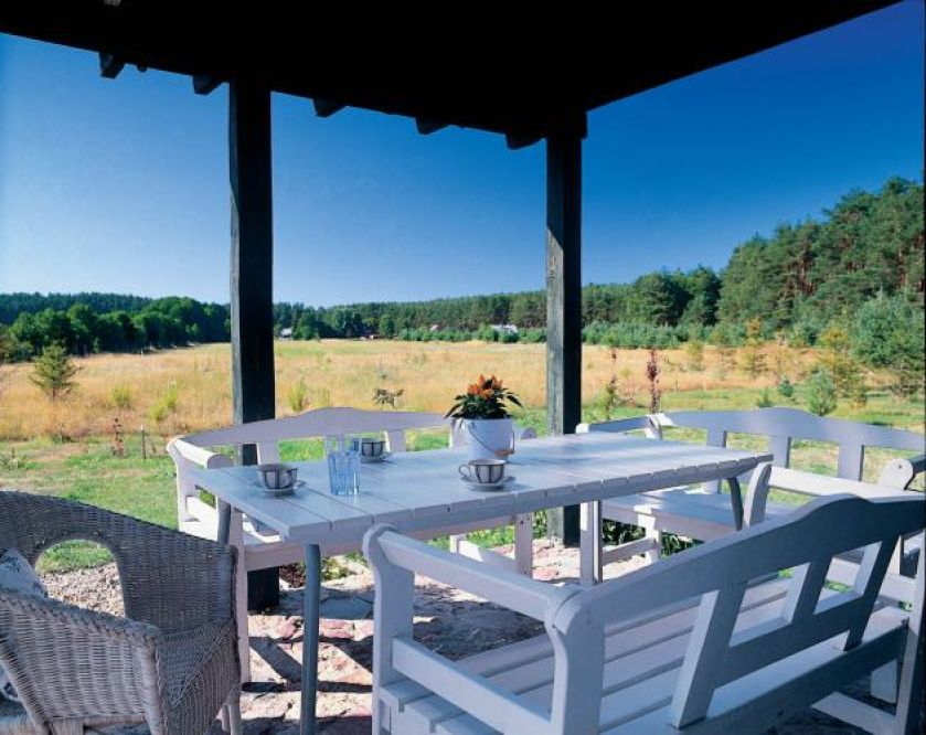 Białe drewniane meble świetnie sprawdzają się na ganku.