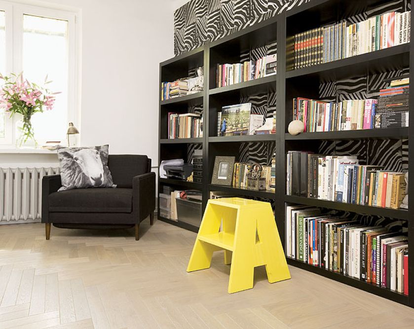 Regał IKEA, żółty stołek ancymon jest projektem One Line Studio Refre. Poduszka z nadrukiem owcy z firmy By Nord.