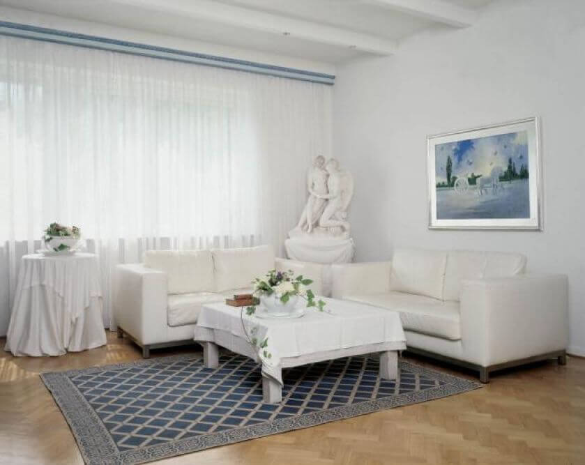 W salonie stoją białe kanapy. Dom w bieli i błękicie