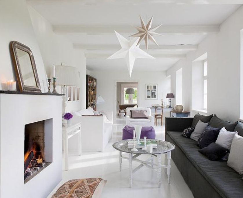 Tina kocha antyki i rękodzieło. Do białych ścian i podłóg odważnie dodaje ciemne poduchy, stare meble i chodniki.