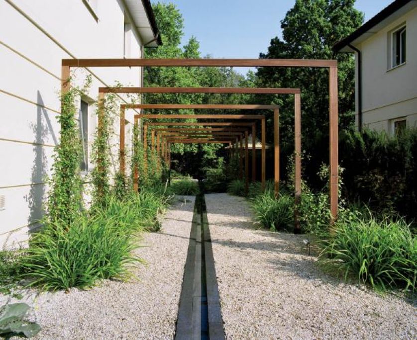 Pod pergolą - modny żwir z granitowymi płytami pośrodku. OGRODY DANKIEWICZ