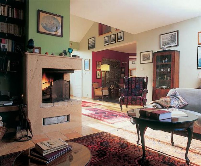 Narożny kominek w salonie. Wnętrza urządzone z tradycją