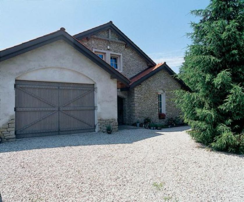 Wokół domu zostały wysypane drobne kamienie. Świetnie komponują się z elewacją domu.