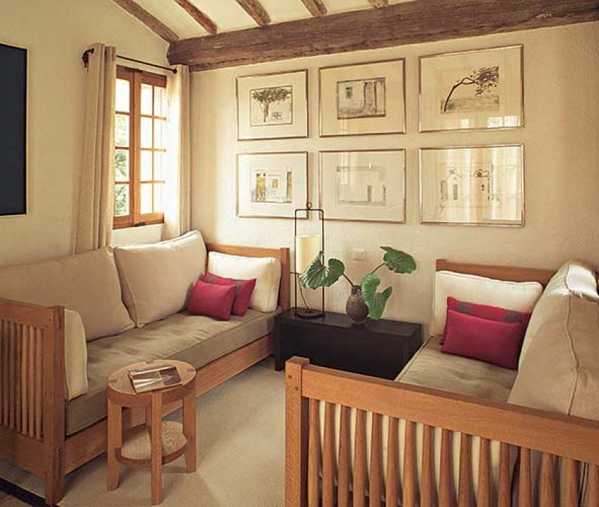 Na ścianie wisi kolekcja obrazków. Kamień i drewno w jednym domu