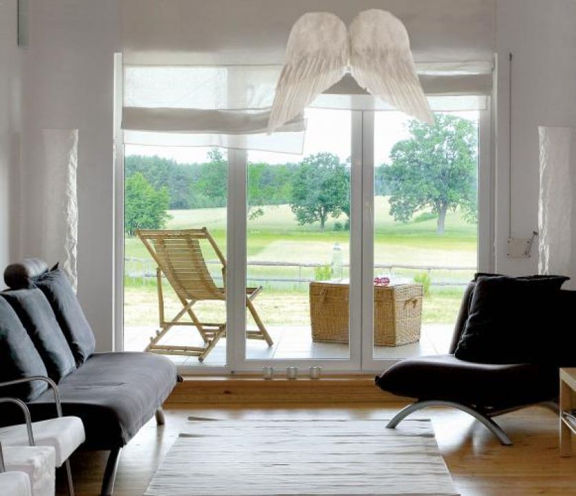 Na drzwiami prowadzącymi na taras wiszą anielskie skrzydła.