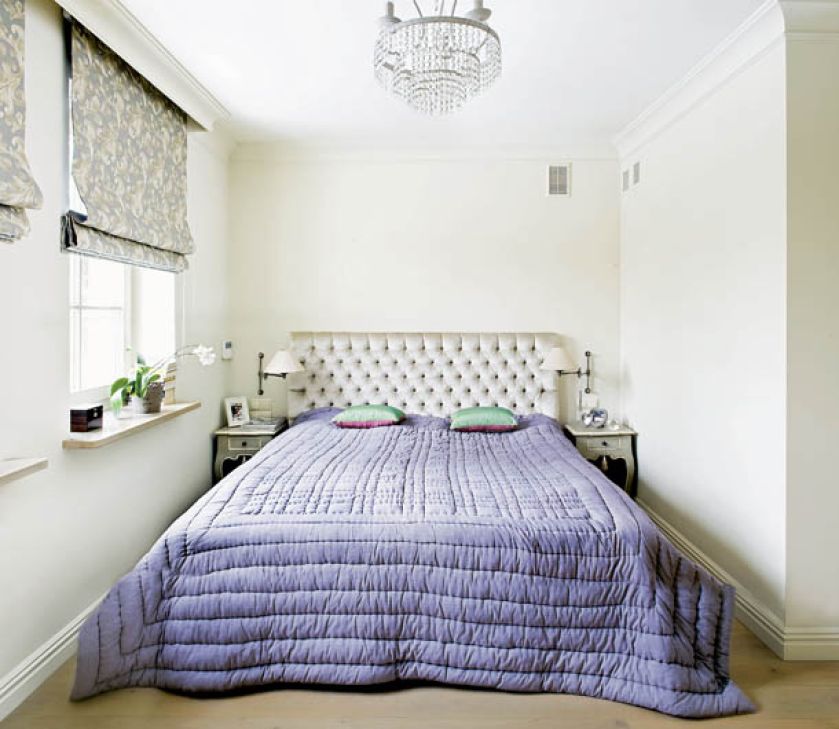 Lawendowa narzuta w sypialni przełamuje jasne kolory ścian.