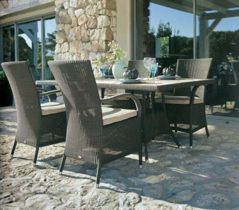 Fotel Mayfair firmy Cane Line zrobiono z włókna hularo (1619 zł), stół - z drewna tekowego i hularo (180