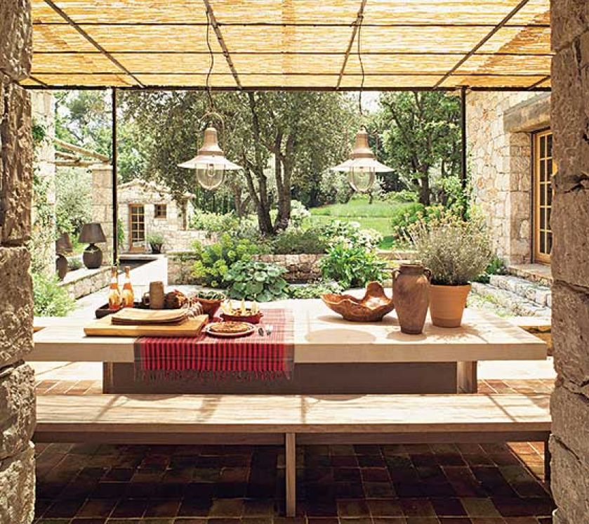 Wprost z kuchni wychodzi się na taras osłonięty bambusowym dachem. Blat stołu został zrobiony z