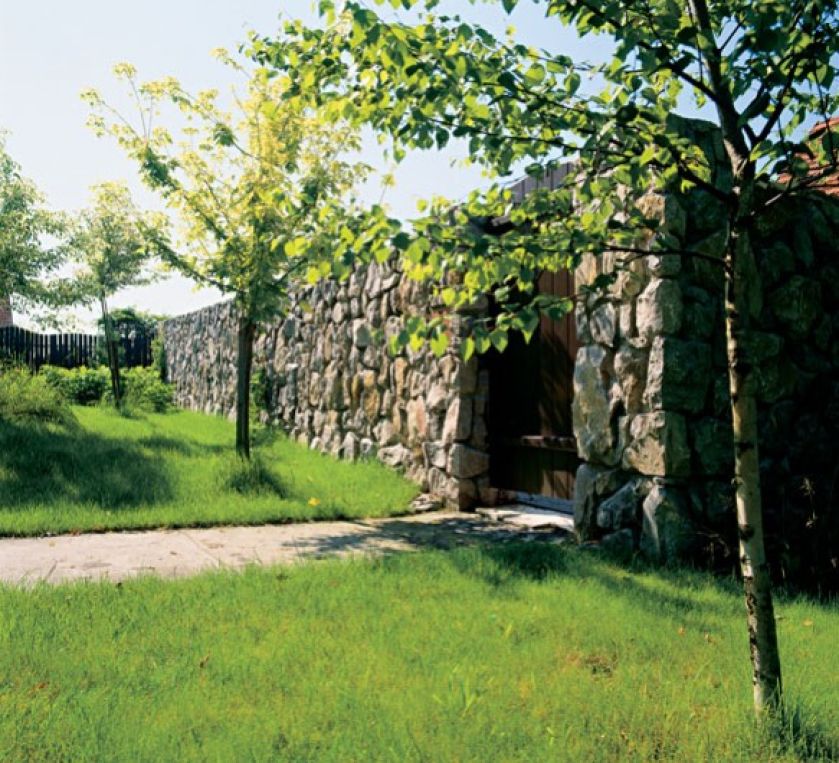 Ogród od drogi odgradza mur z kamienia. Widoku na łąki i pola i las nic nie zasłania.