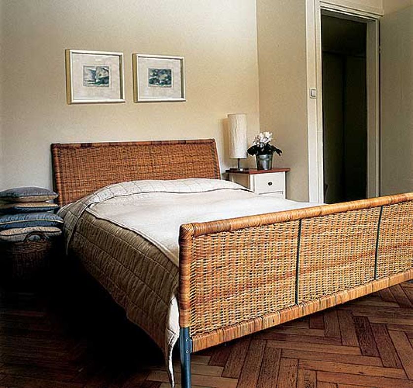 Łóżko ma wiklinową ramę. Różne odcienie bieli