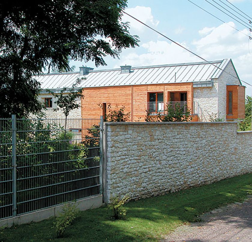 Neutralny budynek wkomponowany w ogród.