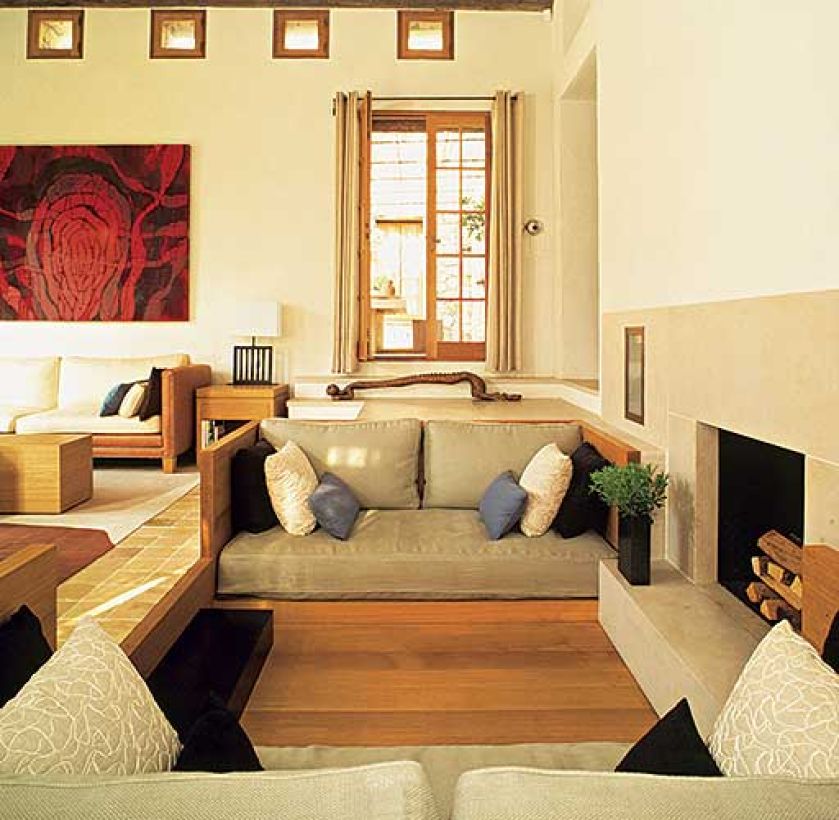 W jasnym salonie akcentem jest obraz namalowany odcieniami czerwieni.