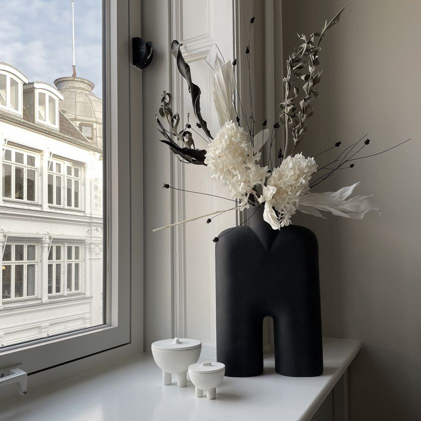 sztuczne kwiaty w designerskim wazonie