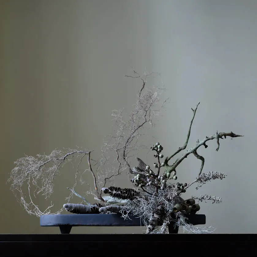 kompozycja ze sztucznych kwiatów na tacy