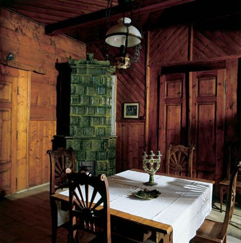 W jadalni stoi zielony piec kaflowy.