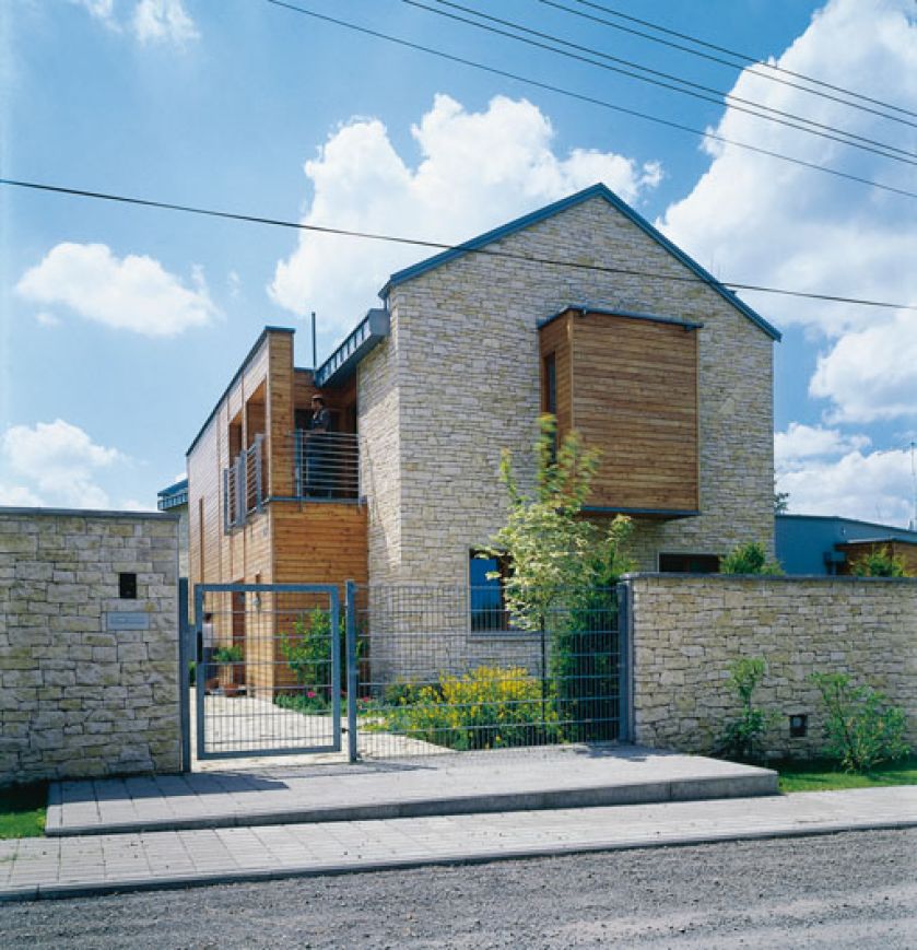 Ogrodzenie także zbudowano z wapienia, aby dobrze komponowało się z elewacją domu.