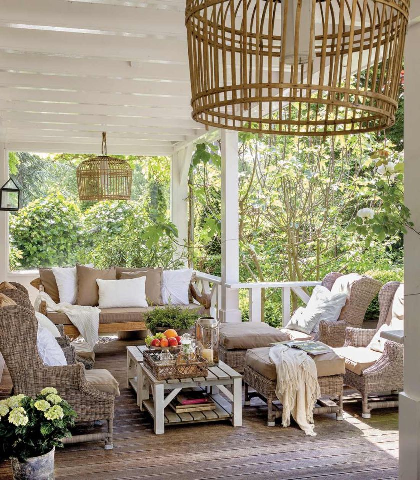 Weranda w prowansalskim stylu z rattanowymi meblami obsadzana została figowymi drzewkami i oleandrami.